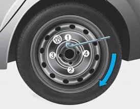 Hyundai Accent tightening lug nuts with a lug wrench in the correct star pattern after lowering the vehicle