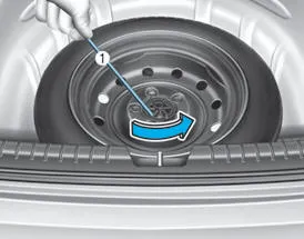 Hyundai Accent using the jack handle to loosen the spare tire hold-down wing bolt